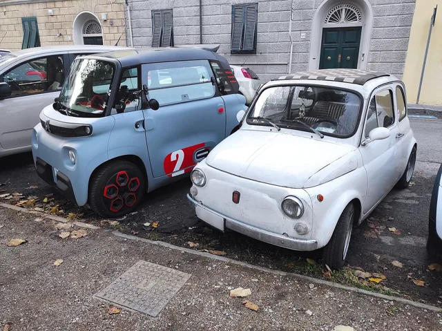 Fiat 500 d'epoca parcheggiata accanto a una Citroën Ami